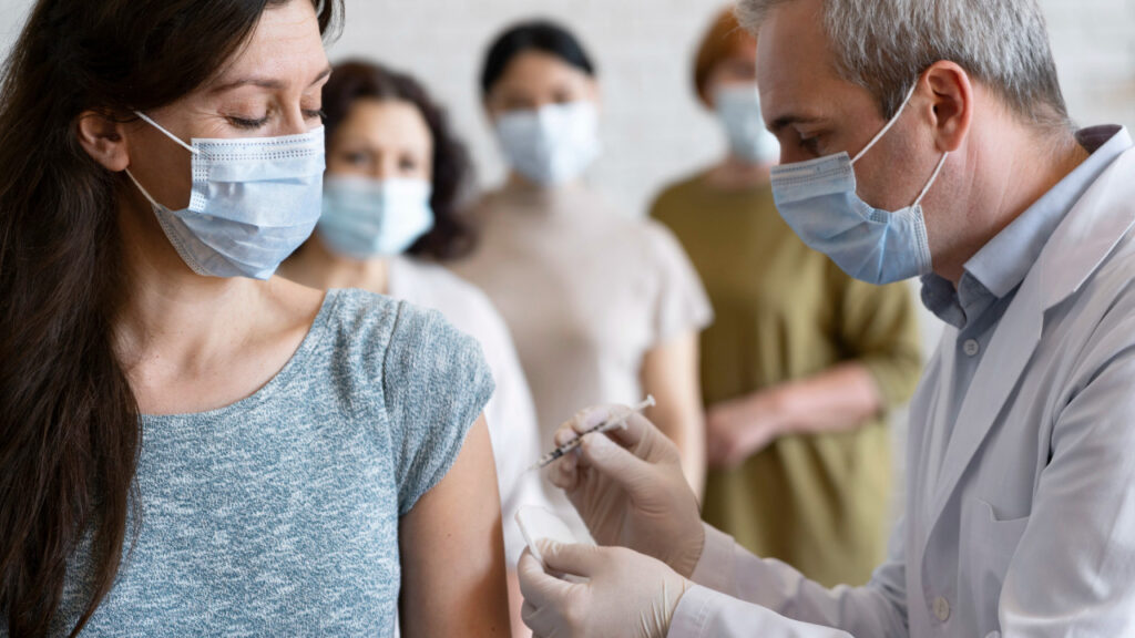 pessoas em fila conscientes sobre a importância da vacinação sendo vacinadas por médico