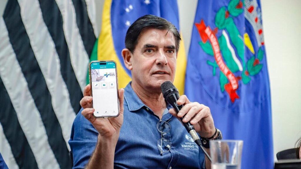 Prefeito Duarte Nogueira segura celular com aplicativo do programa Conecta SUS Ribeirão